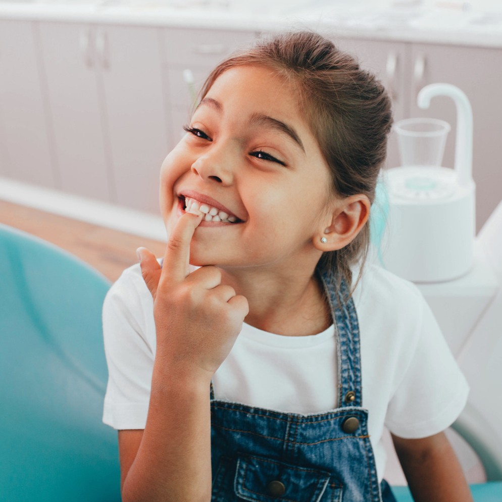AdobeStock_281626595 v2 Girl showing of her clean teeth at the dentist for a preventive dental appointment in Franklin WI