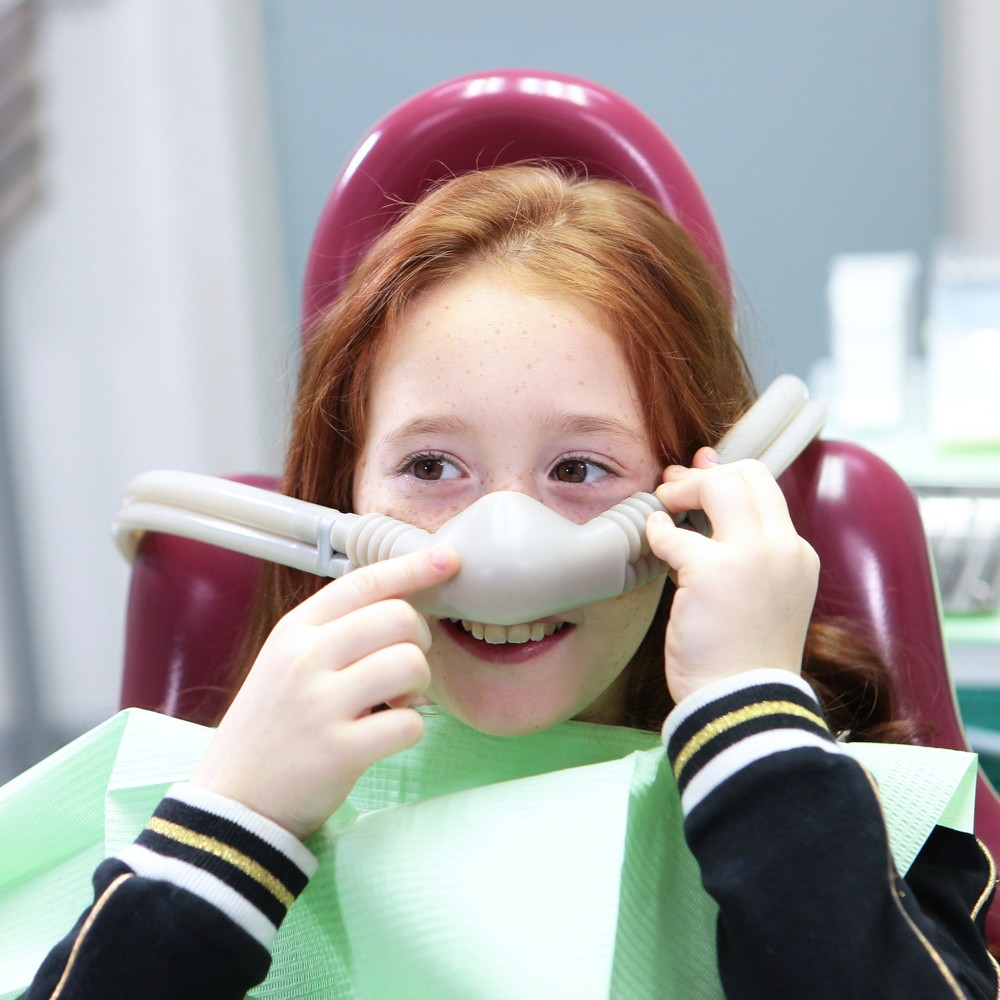 AdobeStock_281626595 v2 Girl showing of her clean teeth at the dentist for a preventive dental appointment in Franklin WI
